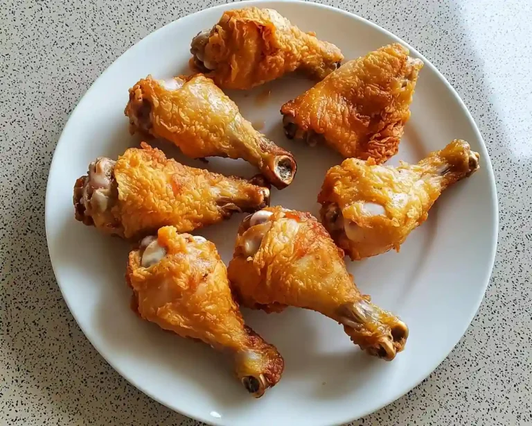 Morceaux de poulet dorés et croustillants disposés sur une assiette - recettes faciles de pilons et cuisses de poulet